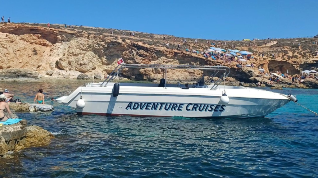 Patrón manejando un barco con grupo de amigos en la costa de Malta