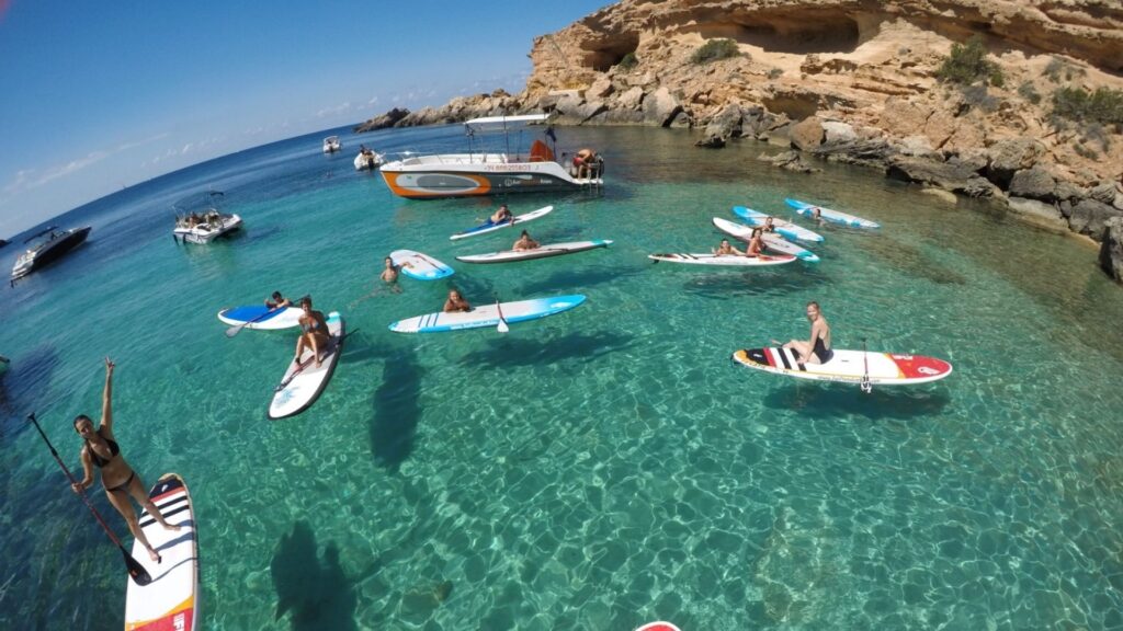 Persona de pie sobre una tabla de paddle surf en una bahía de Malta