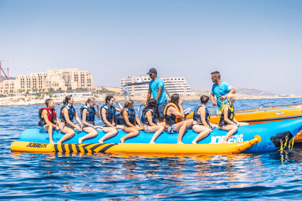 Grupo de personas subidas a una banana hinchable remolcada por lancha en Malta