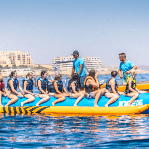 Grupo de personas subidas a una banana hinchable remolcada por lancha en Malta